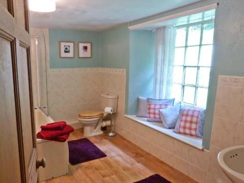 a bathroom with a window with a toilet and a sink at High Kiln Bank Cottage in Ulpha