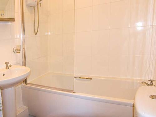 a bathroom with a sink and a tub and a toilet at Tan Y Rhos Isa in Llansantffraid Glyn Ceiriog