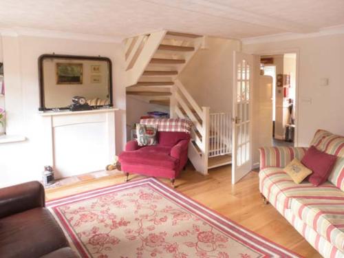 a living room with two couches and a staircase at Ted's Place in Aylsham