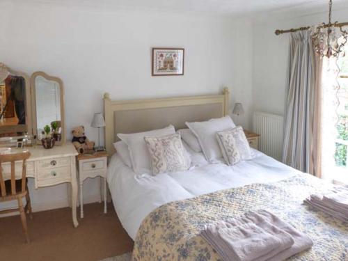 a bedroom with a bed and a desk and a mirror at Ted's Place in Aylsham