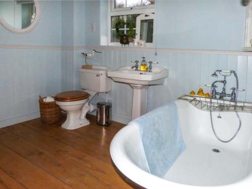 a bathroom with a tub and a sink and a toilet at Ted's Place in Aylsham