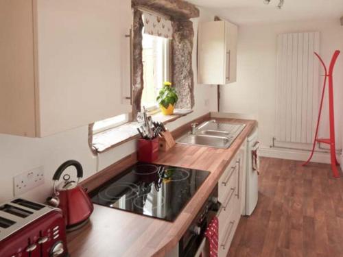a kitchen with a sink and a counter top at Knowle Lodge in Mytholmroyd