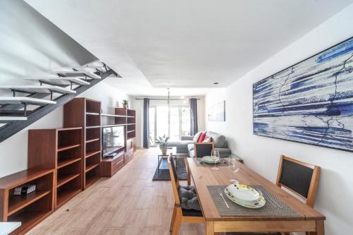 a living room with a dining table and a staircase at Luxury Apartment Gueldera in Playa Honda