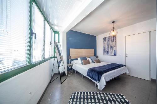 Un dormitorio con una cama y una ventana grande. en Luxury Apartment Gueldera, en Playa Honda