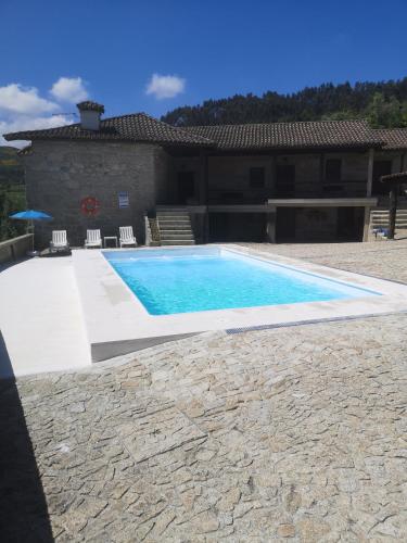 a swimming pool in front of a house at Casa da Anta Grande in Celorico de Basto