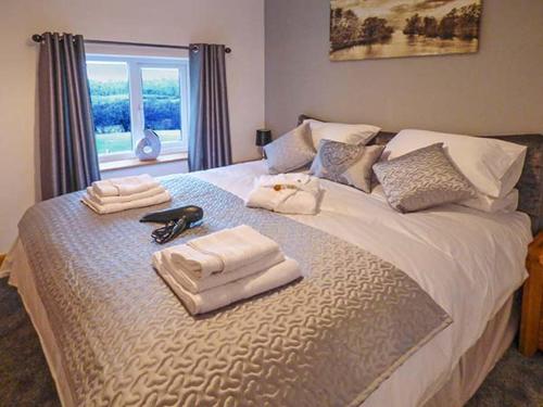 a bedroom with a bed with towels and a window at Cwmcelyn in Nantmel