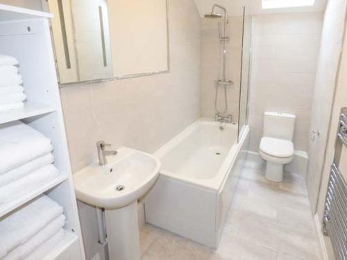 a white bathroom with a sink and a toilet at Old Church Coach House in Church Leigh