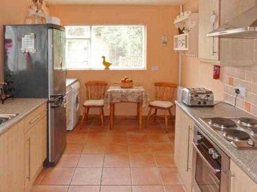 a kitchen with a table with chairs and a refrigerator at Elizabeth House in Hornsea