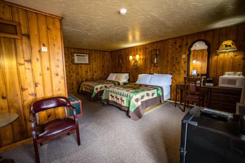 a bedroom with two beds and a desk and a tv at Riverside Motel in Hayward