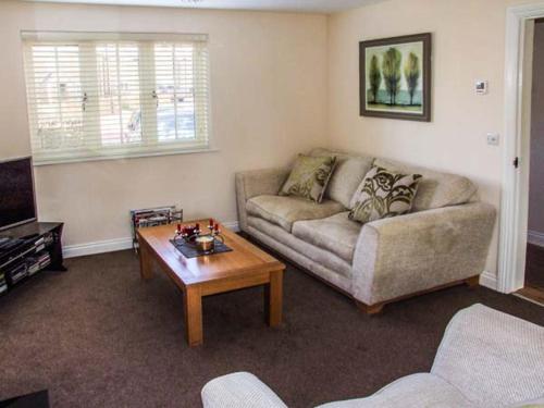a living room with a couch and a coffee table at Jubilee Mews in Andoversford