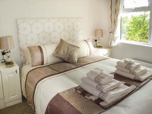 a bedroom with a bed with towels on it at Chaffinch Lodge in Highampton