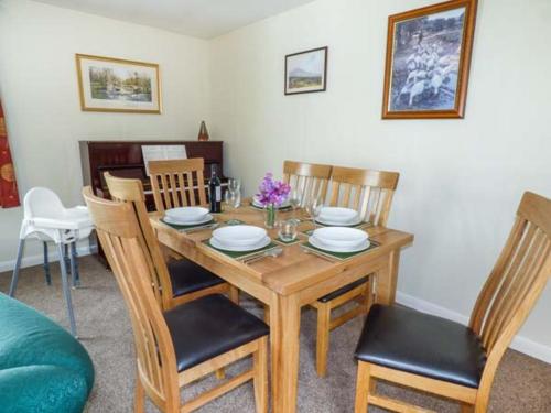 a dining room with a wooden table and chairs at Moorside in Horrabridge
