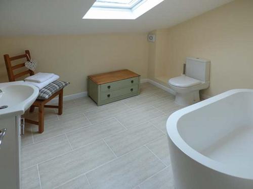 a bathroom with a tub and a toilet and a sink at Hillside View in Hawes