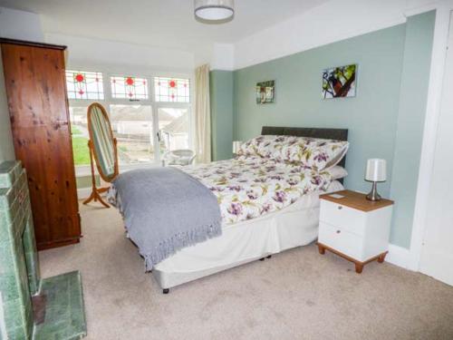 a bedroom with a bed and a table and a window at Pen Hill in Llantwit Major