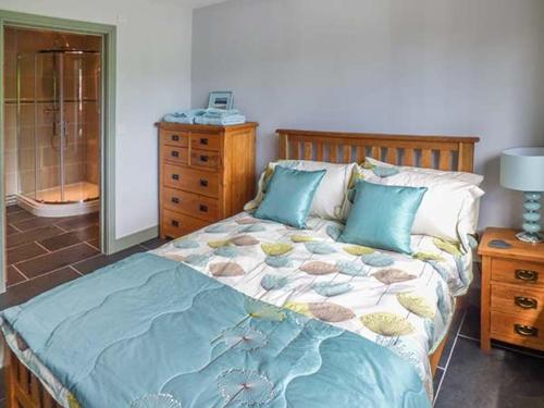 a bedroom with a bed and a dresser at The Lodge, Lower Trefedw in Pandy