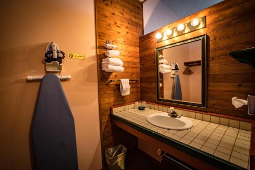 W łazience znajduje się umywalka, lustro i ręczniki. w obiekcie Riverside Motel w mieście Hayward