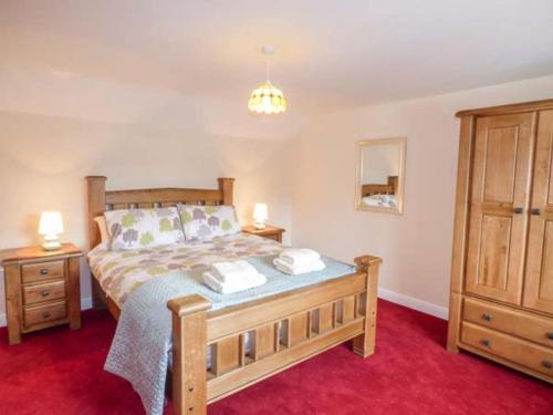 a bedroom with a bed with two night stands and two lamps at Maerdy Cottage in Bettws Gwerfil Goch