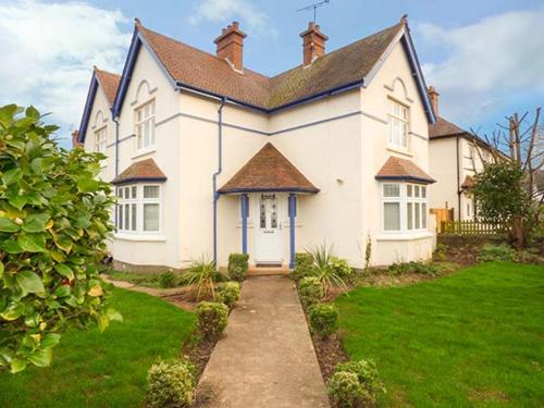 a large white house with a grass yard at Lily House in Minehead