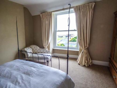 a bedroom with a bed and a window at Sea View Apartment in Llanfairfechan