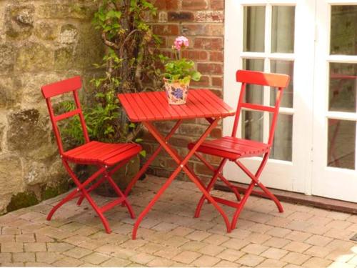 duas cadeiras vermelhas e uma mesa vermelha com um vaso de plantas em Beech View em Malton