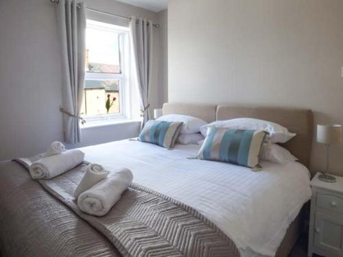 a bedroom with a large bed with towels on it at Silversands Cottage in Amble