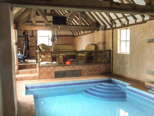 a large swimming pool in a room with at Finwood Cottage 1 in Rowington
