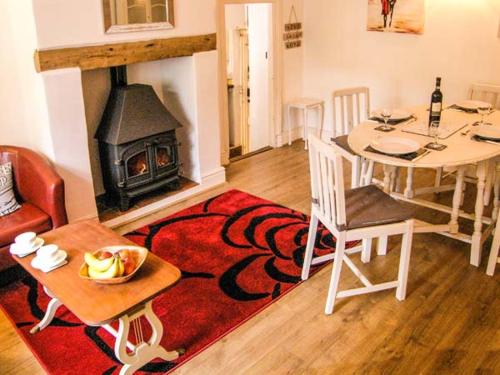 a living room with a table and a fireplace at St Margaret's Cottage in Chardstock