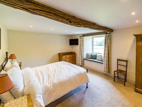 a bedroom with a large bed and a window at Dale House Farm Cottage in Weathercote