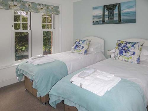 a bedroom with two beds and a window at 4 The Nab House in Bembridge