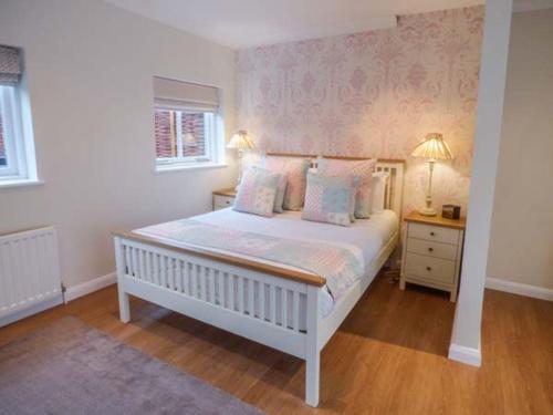 a white bedroom with a white bed with pillows at Walworth Castle Holiday Cottage in Walworth