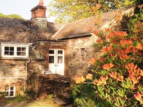 an old stone house with a white door at Townhead Farmhouse in Patterdale