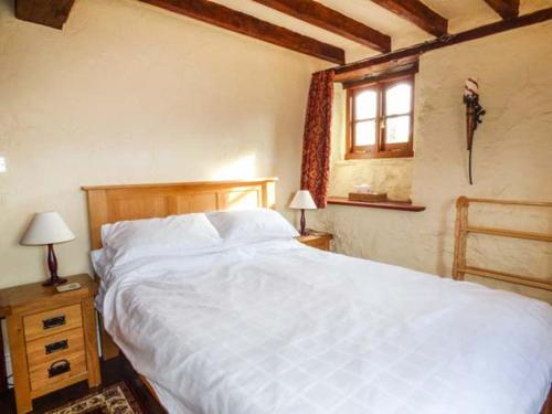 a bedroom with a large white bed and a window at Yr Hen Felin in Carrog