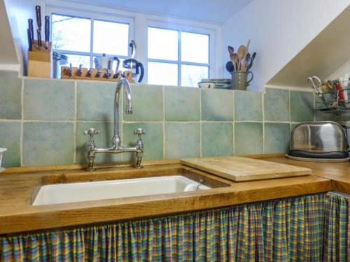 uma cozinha com um lavatório e uma bancada em Townhead Cottage em Patterdale