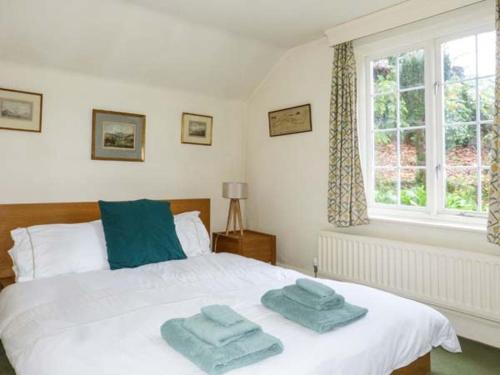 a bedroom with a bed with two towels on it at Townhead Cottage in Patterdale