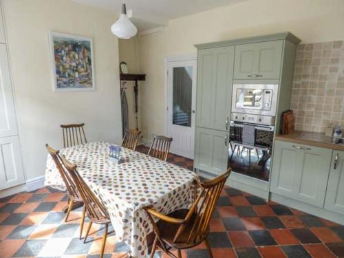 a dining room with a table and chairs in a kitchen at 2 Cae Glas in Penmaen-mawr