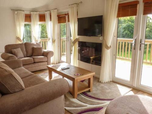 a living room with a couch and a table at Morgan Lodge in Puxton