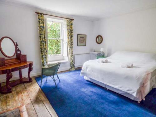 a bedroom with a bed and a desk and a window at Flanders Hall in West Burton