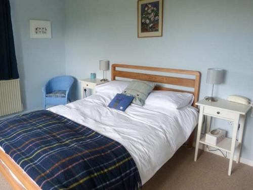 Un dormitorio con una cama con una almohada azul. en Fronthill en Newtonmore