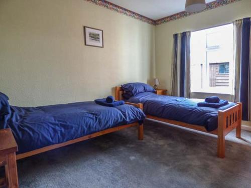 two beds in a room with a window at Glenhaven in Rendham