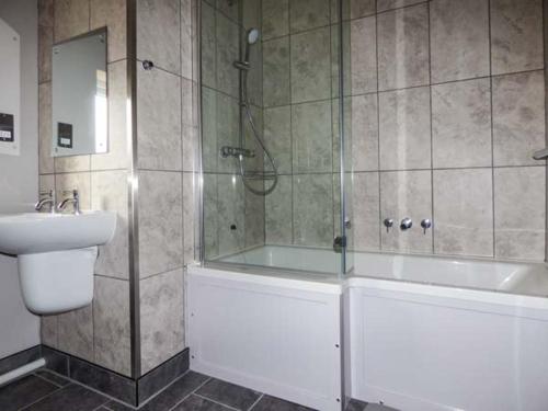 a bathroom with a shower and a tub and a sink at Glenhaven in Rendham