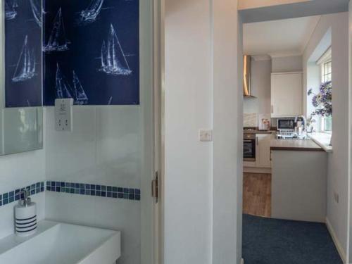 a white kitchen with a sink and a counter top at Herbrand House in Bexhill