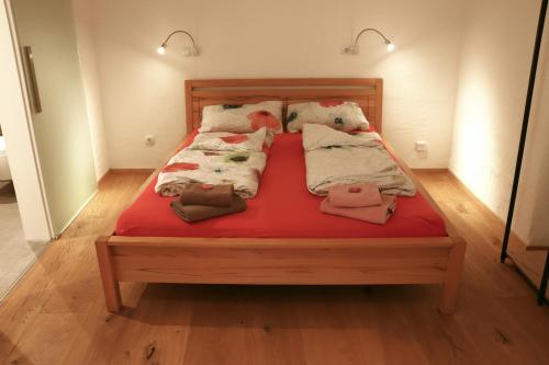a bed with red sheets and pillows on it at Stilvolle Wohnung auf 50 m² mit Parkplatz und WiFi in Kraiburg am Inn