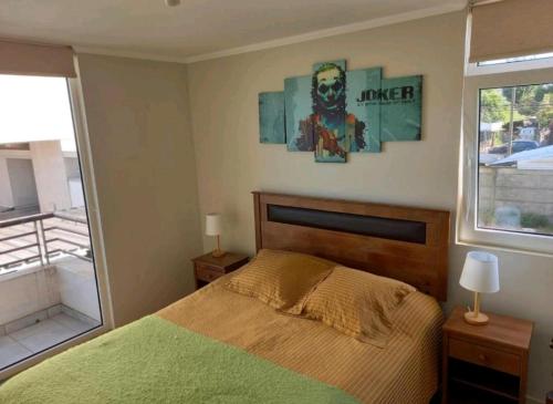 Un dormitorio con una cama verde y una ventana. en Espacio GINEBRA, en Temuco