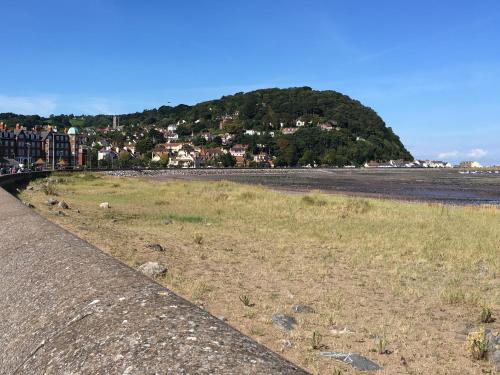 a view of a beach with a hill in the background at 3 Old Police Station in Dunster