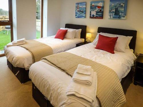 BroadweyにあるCasterbridgeのベッドルーム(赤い枕付きのベッド2台付)