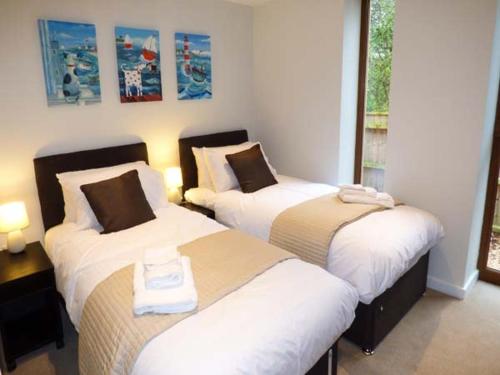 ein Hotelzimmer mit 2 Betten und einem Fenster in der Unterkunft Shepherd Oak in Broadwey
