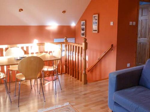 a living room with a couch and a table and chairs at Stemster School House Apartment in Castletown