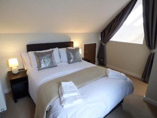 a bedroom with a large white bed with a window at Budmouth in Broadwey
