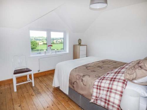 a bedroom with a large bed and a window at Caeau Mawr in Henllan