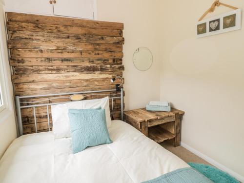 a bedroom with a bed and a wooden headboard at Middle Hivron in Bleddfa